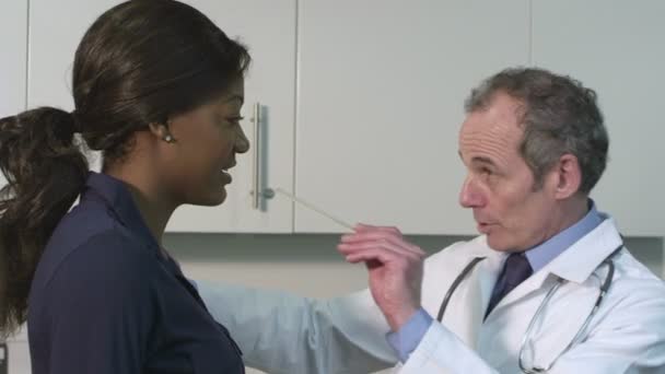 Лікар, який обстежує пацієнта — стокове відео