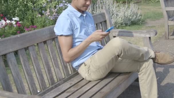 Młody człowiek korzystający z telefonu komórkowego — Wideo stockowe