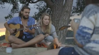 Arkadaşlar kamp ateşi yakın müzik keyfi