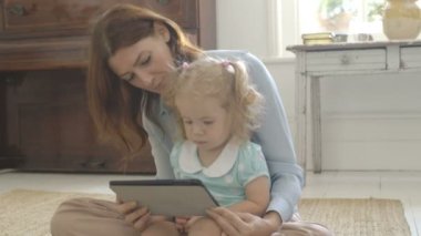 Anne kızına dijital tablet gösterilen