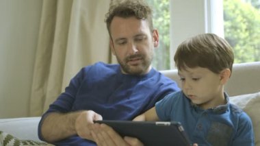 Baba ve oğul dijital tablet üzerinde oynama