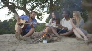 Arkadaşlar kamp ateşi yakın müzik keyfi