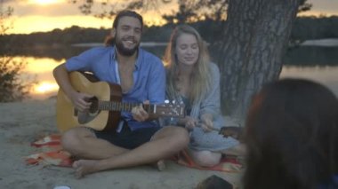 Arkadaşlar kamp ateşi yakın müzik keyfi