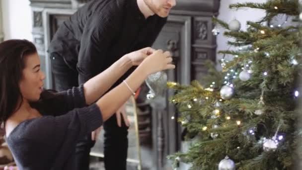 Hombre y mujer decorando el árbol de Navidad — Vídeos de Stock