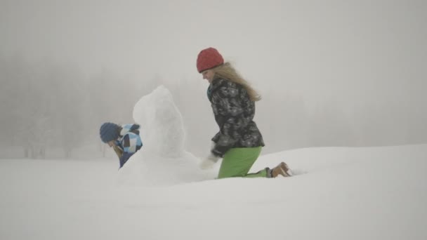 Mujeres haciendo muñeco de nieve — Vídeo de stock