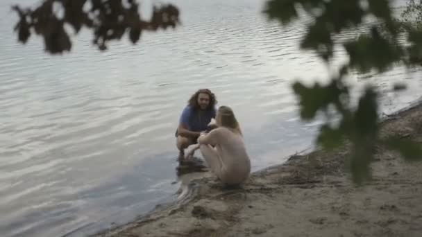 Paar sitzt am Flussufer — Stockvideo