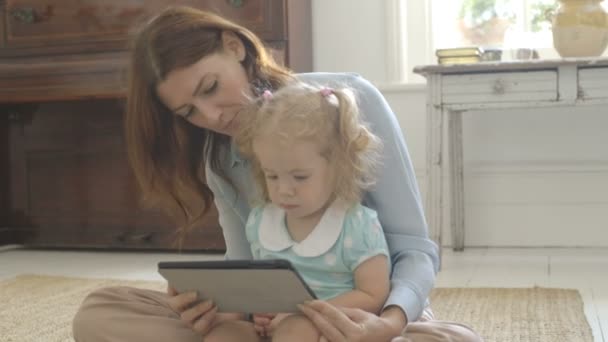 Mother showing digital tablet to her daughter — Stock Video