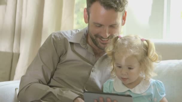 Père montrant tablette numérique à sa fille — Video