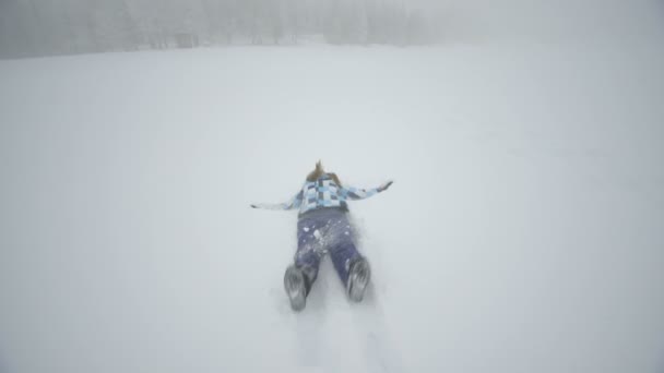 Frau legt sich auf Schnee — Stockvideo