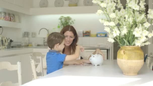 돈을 저축 하기 위해 돕는 아들을 어머니 — 비디오