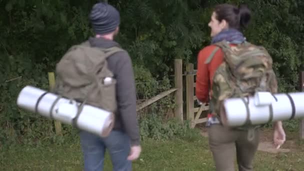 Couple walking through wooden gate — Stock Video