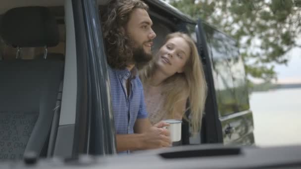 Couple assis dans une voiture tenant des tasses — Video