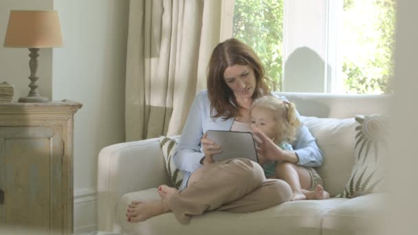 Mother showing digital tablet to her daughter — Stock Video