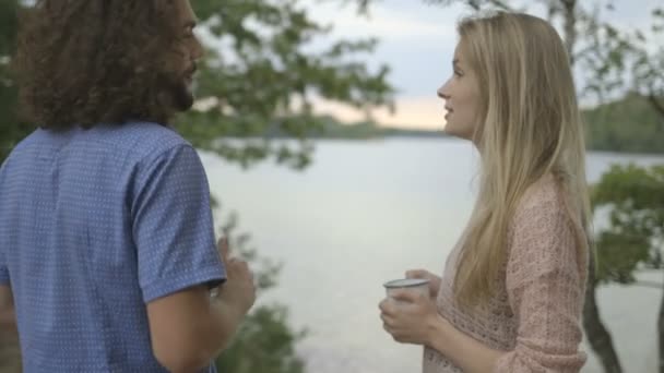 Pareja de pie en la orilla del río — Vídeos de Stock