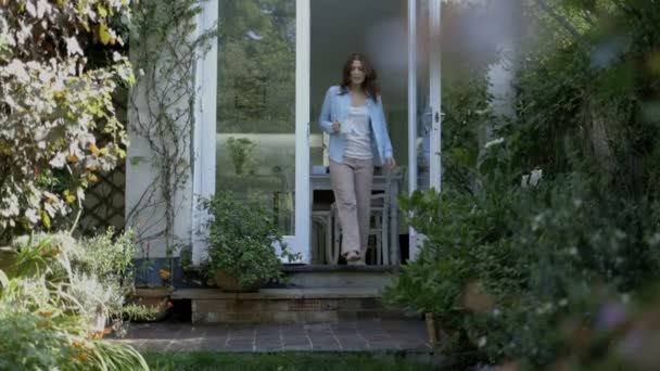 Vrouw genieten van koffie in de tuin — Stockvideo