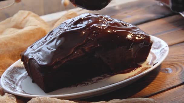 那女孩用巧克力把蛋糕铺了起来 用巧克力糖霜浸透巧克力蛋糕 巧克力软糖 自制烘焙 木制背景的巧克力蛋糕 — 图库视频影像