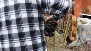 Adam ateş için odun topluyor. Ekose gömlekli taşralı çocuk.