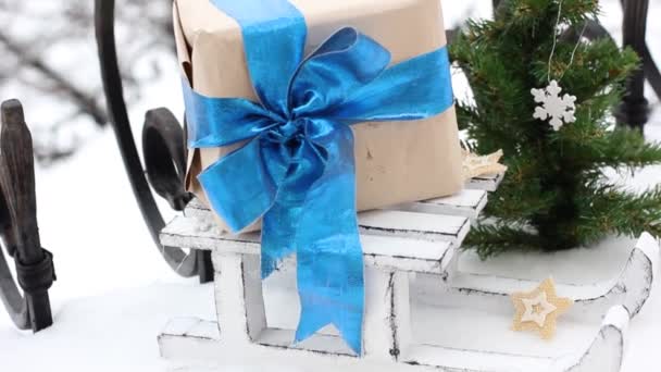 クリスマスの精神 そりの上に弓で贈り物 雪の中のクリスマスの装飾 — ストック動画