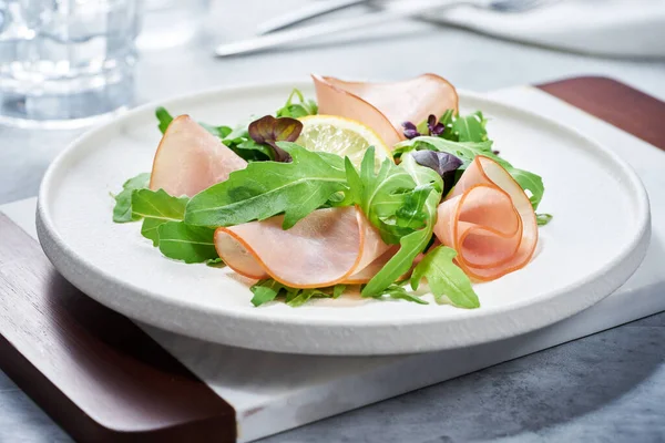 Jambonlu salata ve beyaz tabakta roka. Telifsiz Stok Fotoğraflar