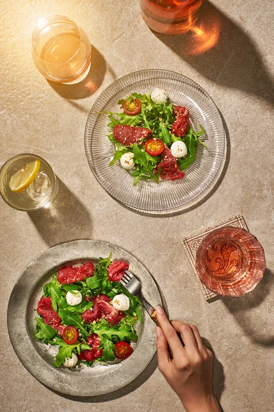 Saladas de carne em pedra mesa ensolarada com bebidas Imagem De Stock