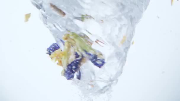 Raspas de laranja e flores girando em vórtice de água — Vídeo de Stock