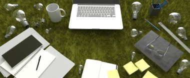 Çimlerin üzerinde dizüstü bilgisayarlar olan bir masa..