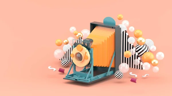 Old camera floating among colorful balls on pink background.-3d render