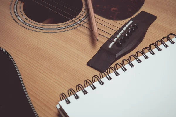 Lápiz y papel sobre guitarra en estilo vintage — Foto de Stock