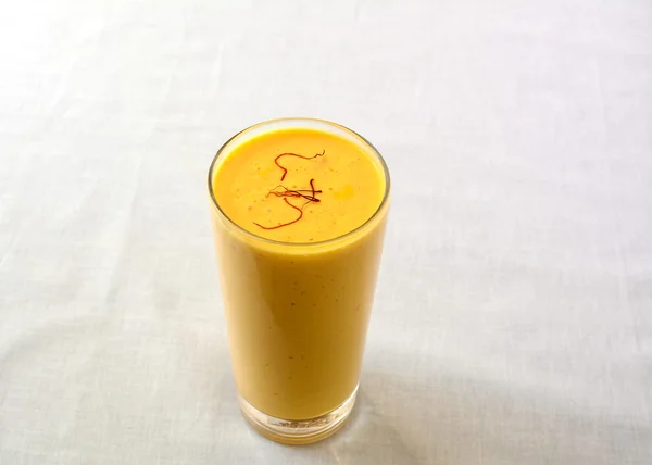 Mango lassi bir bardak, bir tatlı Hint güler yüzlü, safran ile serpilir