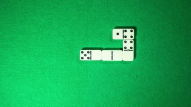 Yeşil kumaş arka plan üzerinde stop motion domino oyunu. Sarmal formu.