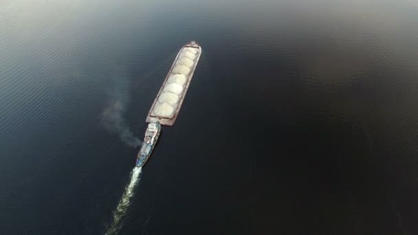 Вид с воздуха на буксирную лодку, толкающую баржу песка — стоковое видео