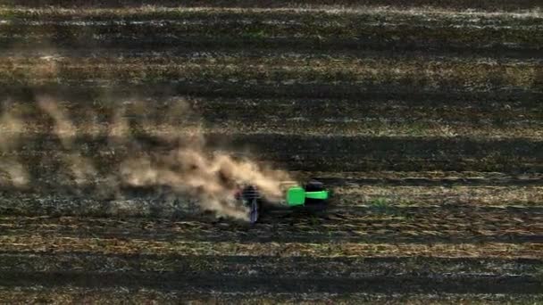 Luchtfoto van trekker ploegen van de bodem op zonsondergang — Stockvideo