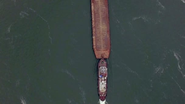 Aerial view of tug boat pushing empty barge — Stock Video