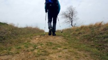 Bir sırt çantası ve trekking Polonyalılar ile mavi ceketli adam turist açık yürür