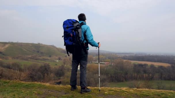 Mann in blauer Jacke und Rucksack genießt sein Klettern — Stockvideo