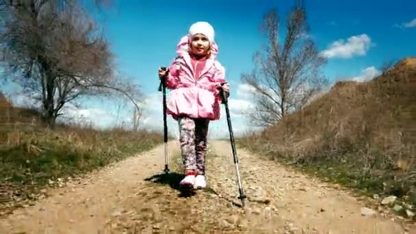 Kanyonda trekking direkler ve bir sırt çantası ile pembe ceket küçük kız uzun yürüyüşe çıkan kimse yürür — Stok video