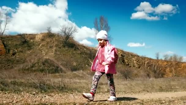 Malá dívka tramp v růžové sako s batohem chodí v kaňonu — Stock video