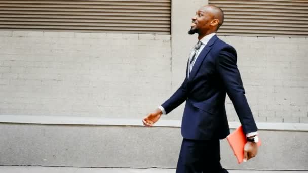 Hombre de negocios afroamericano caminar con la tableta al aire libre — Vídeos de Stock