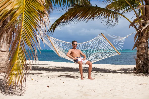 Homme dans un hamac sur la plage — Photo