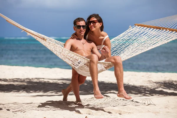 Casal romântico relaxante na rede de praia — Fotografia de Stock