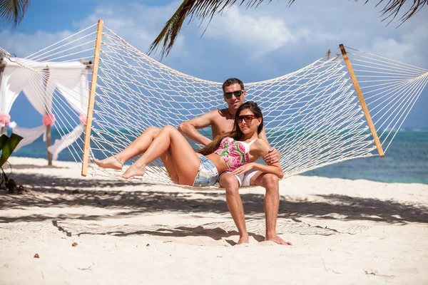 Casal romântico relaxante na rede de praia — Fotografia de Stock