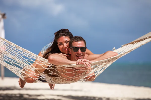 Casal romântico relaxante na rede de praia — Fotografia de Stock