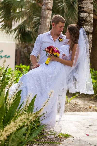 Bruden och brudgummen på bakgrund av palmer — Stockfoto