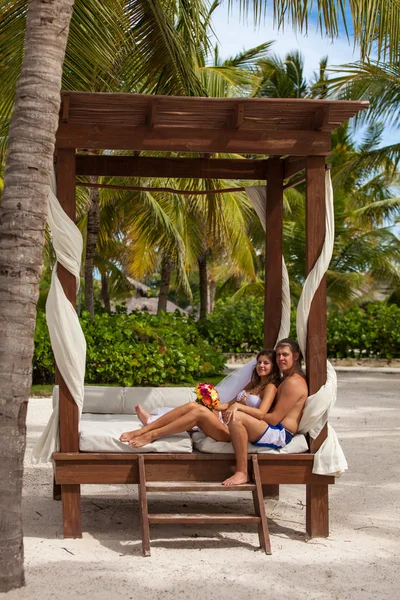 Mann und Frau relaxen auf Sonnenliegen am Strand — Stockfoto