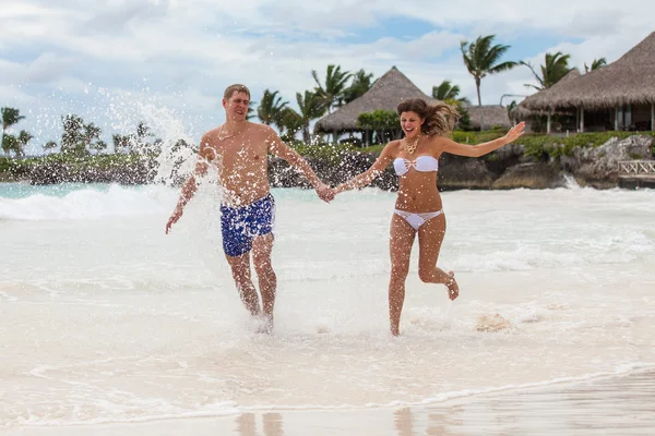 Couple Running Through Waves On Beach Holiday — Stock Photo, Image