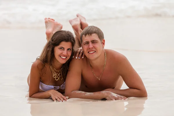 Young couple lie on the ocean beach — Stock Photo, Image