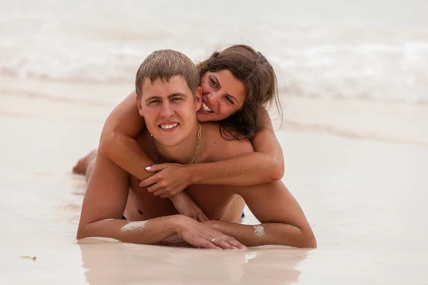 对年轻的夫妇躺在海滩上 — 图库照片