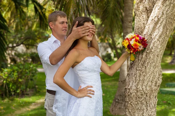 Nevěsta a ženich na pozadí palem — Stock fotografie