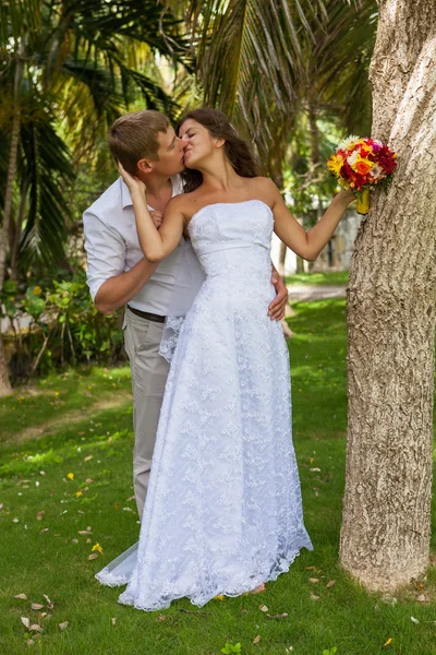 Bride and groom on the background of palm trees — Stock Photo, Image