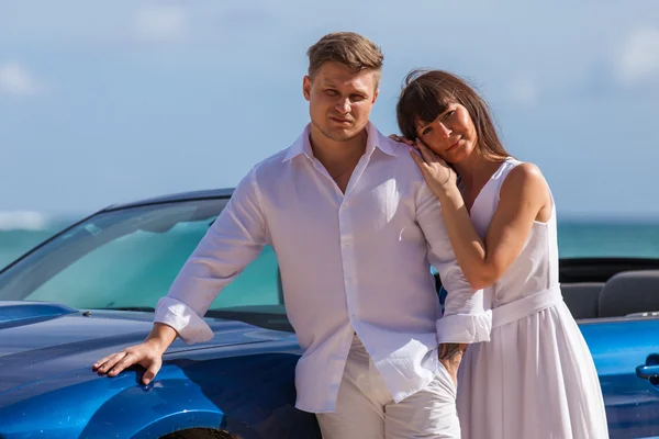 Strand paar in de buurt van converteerbare auto op het strand — Stockfoto